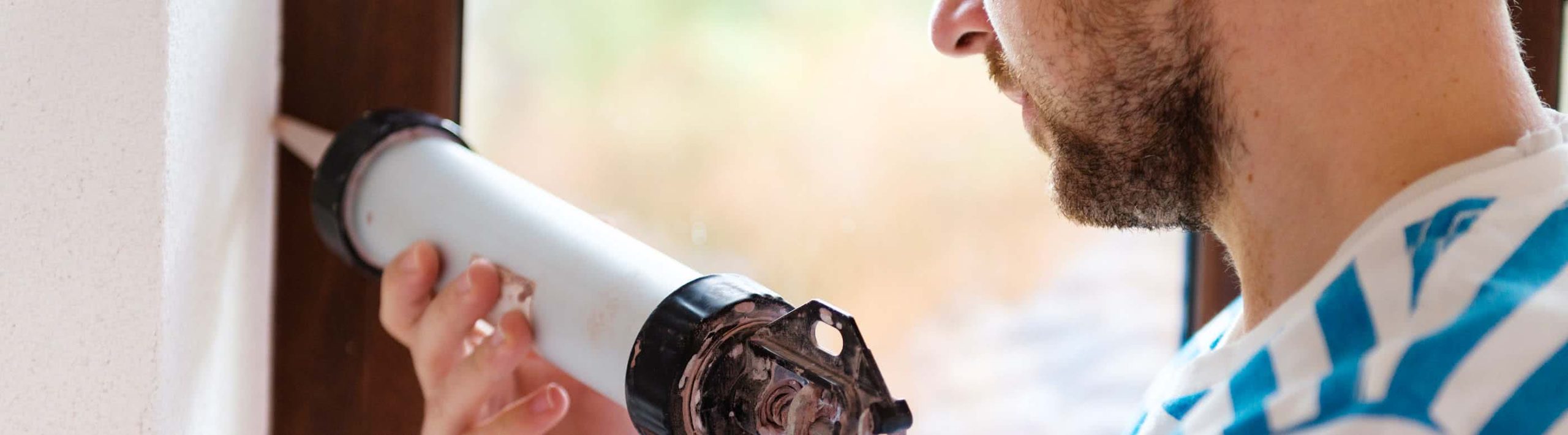 man-caulking-window-sill