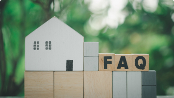 Wooden children's blocks are stacked on top of each other. One of the blocks looks like a house. Three blocks have one letter painted on them each. They spell out, "FAQs."