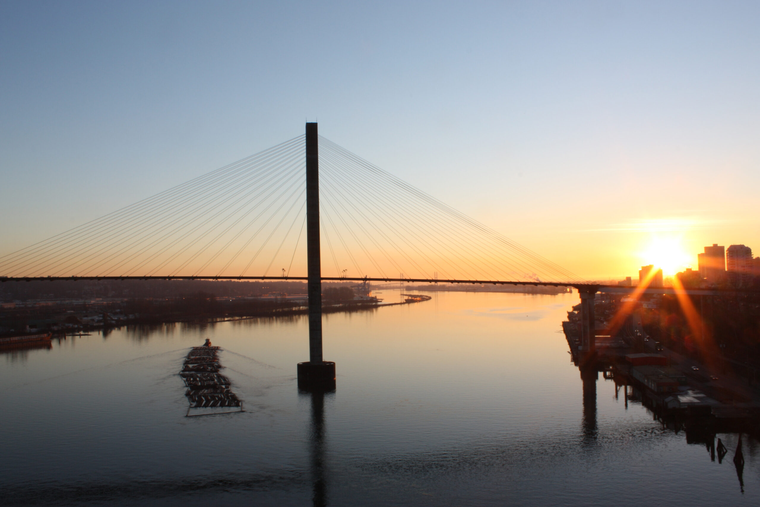 The sun is setting behind the Pattullo Bridge in New Westminister.