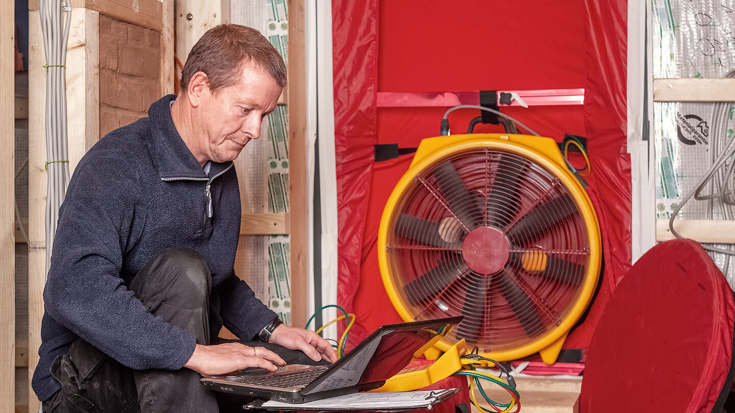 An energy advisor conducts a blower door test